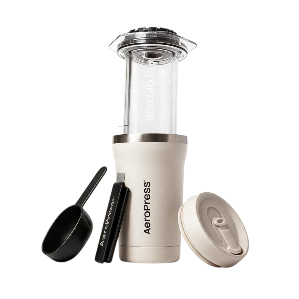 whb-superb AeroPress Go Plus Kaffeebereiter in Creme mit Edelstahlbecher, Kaffeelöffel und Rührstab auf Weiß
