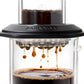 whb-superb AeroPress Premium Kaffeepresse aus Borosilikatglas und Edelstahl beim Brühvorgang mit schwarzem Kaffee.