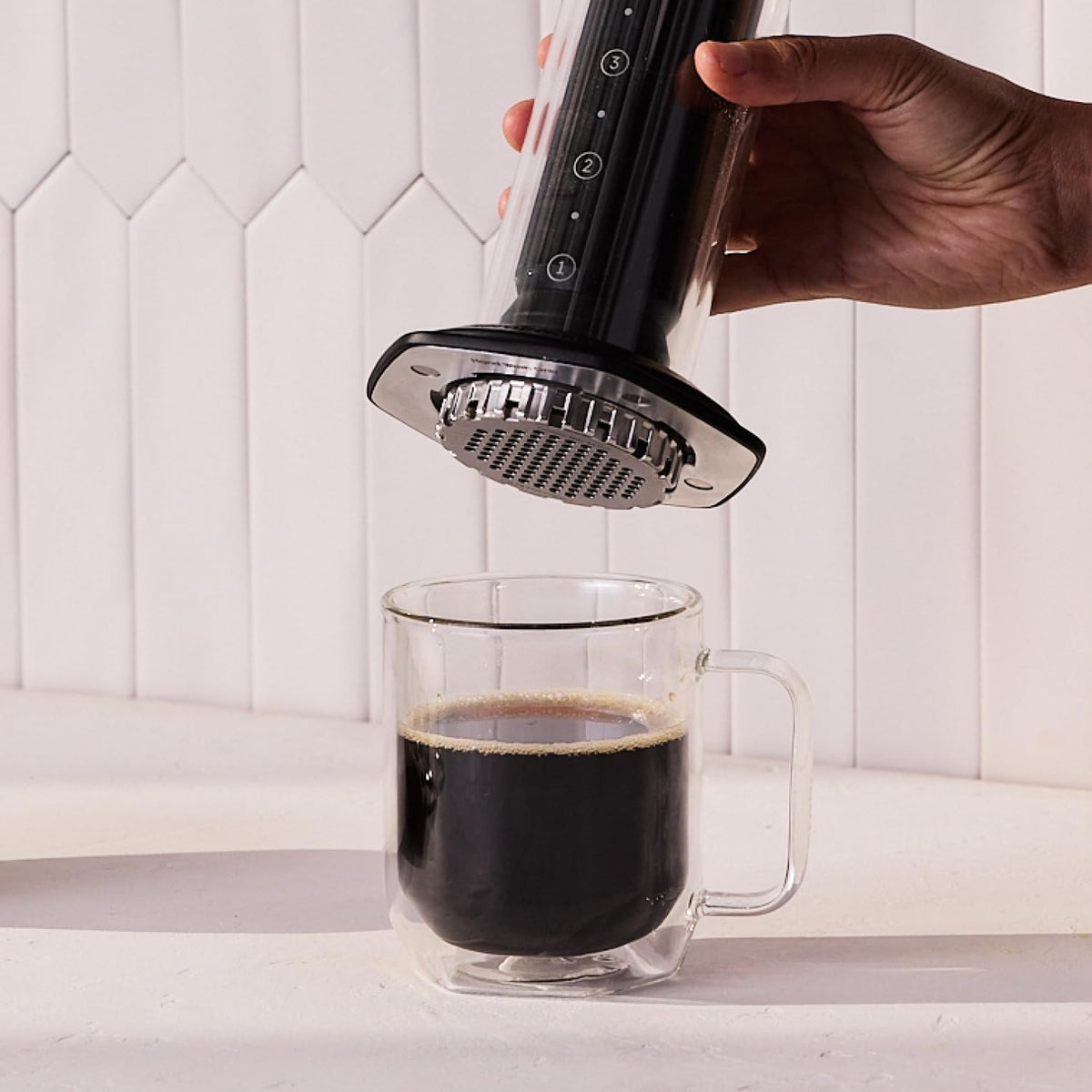 whb-superb AeroPress Premium Kaffeepresse aus Glas und Edelstahl in Schwarz beim Brühen über einer Kaffeetasse