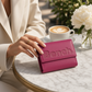 whb-superb Bench Damen Geldbörse aus magenta Leder mit geprägtem Logo auf einem Marmortisch neben einer Kaffeetasse