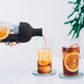 whb-superb Hario Cold Brew Weinflasche aus Glas in Schwarz beim Einschenken von Kaffee mit Orangenscheiben