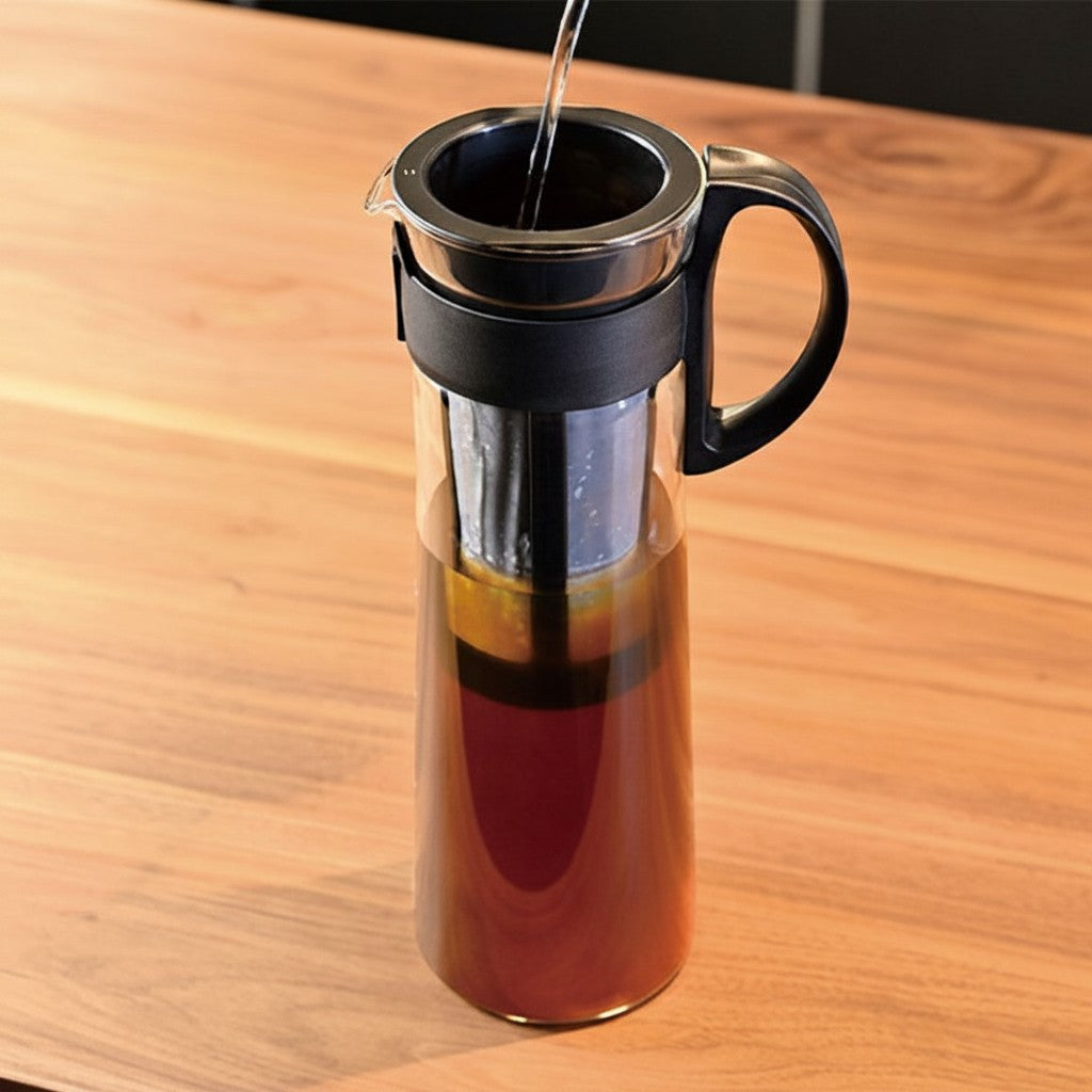 whb-superb HARIO Cold Brew Kaffeekanne aus Glas mit schwarzem Kunststofffilter und Griff auf Holztisch