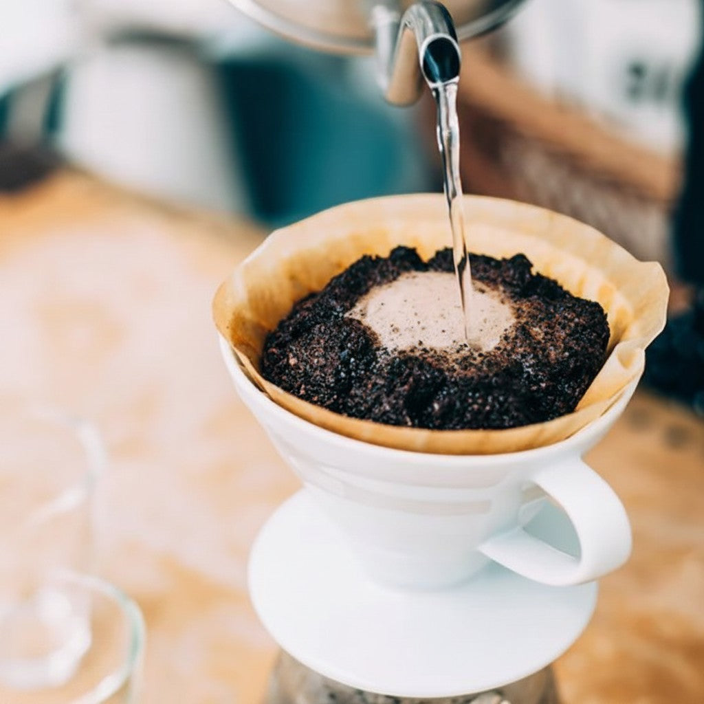 whb-superb HARIO V60 02 Keramik Kaffeefilter in Weiß beim Aufgießen von Kaffee mit einem Papierfilter