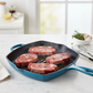 whb-superb LE CREUSET quadratische Gusseisen-Grillpfanne in Deep Teal mit vier rohen Steaks auf einer Küchenarbeitsplatte