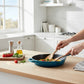 whb-superb Le Creuset Gusseisen Bratpfanne in Deep Teal, 26 cm, beim Zubereiten von Speisen in heller Küche.