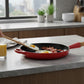 whb-superb LE CREUSET Signature Gusseisen-Bratpfanne in Kirschrot mit Holzgriff beim Braten von Eiern und Speck