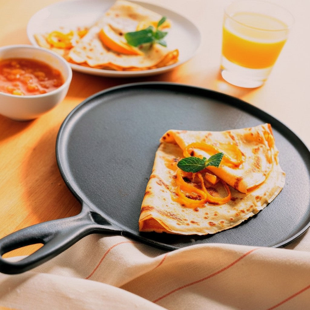 whb-superb Le Creuset Gusseisen-Crêpespfanne in Schwarz mit frisch zubereitetem Crêpe auf einem Holztisch