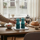 whb-superb Le Creuset Mini Salz- und Pfeffermühlen-Set in Karibik auf einem Frühstückstisch mit Keramik-Mahlwerk.