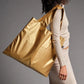whb-superb LOQI Tragetasche in mattem Gold aus wasserfestem Polyester, getragen über der Schulter