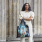whb-superb LOQI Einkaufstasche mit Queen Elizabeth II Motiv von Cecil Beaton, getragen von einer Frau im hellen Outfit