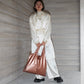 whb-superb LOQI Tragetasche in mattem Roségold, getragen von einer Frau in einem hellen, eleganten Outfit.