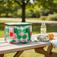whb-superb Rex London Lunchtasche Daisy aus recyceltem Kunststoff mit pink-grünem Gänseblümchen-Muster auf Picknicktisch
